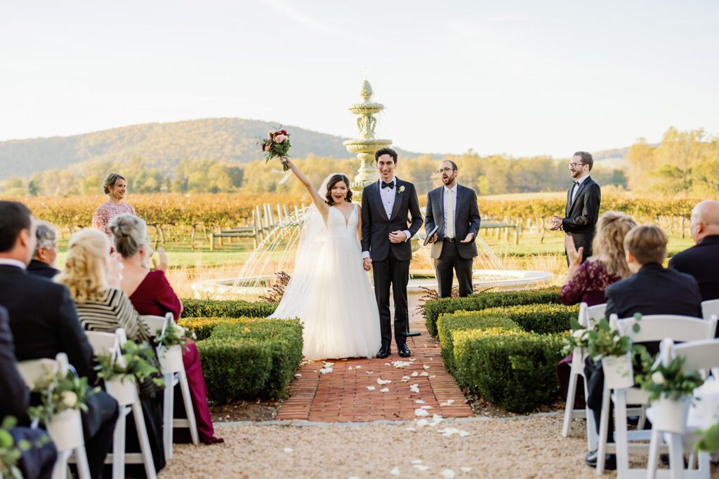couple cheering during their fall keswick vineyard ceremony