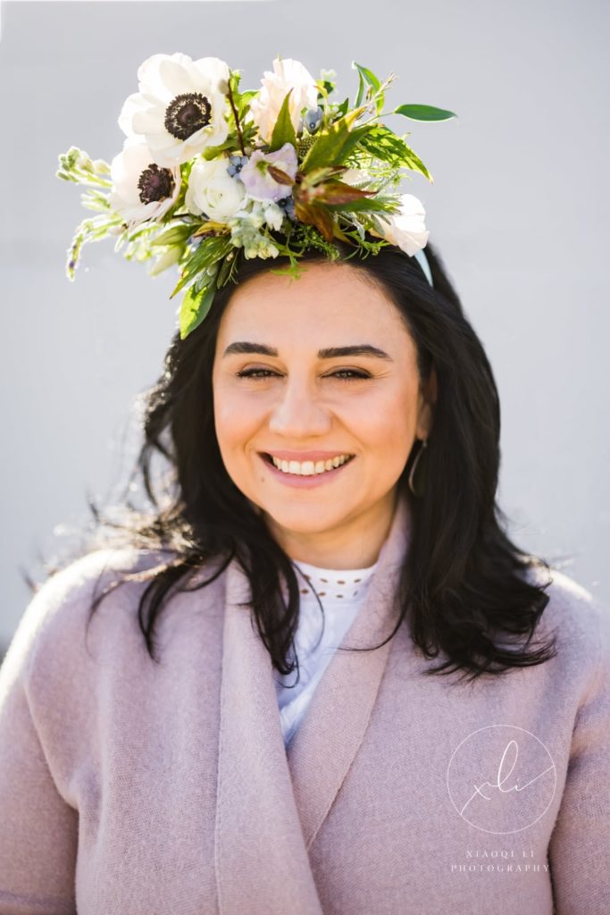Gohar, smiling at the camera wearing a floral crown celebrating International Women's Day