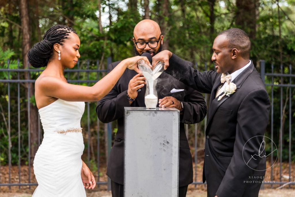 bride and groom pouring sand into one container during symbolic wedding ceremony
