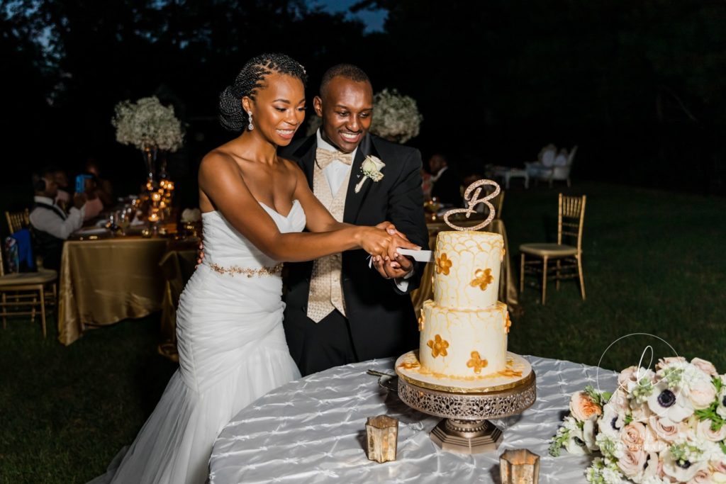 bride and groom cutting into cake 