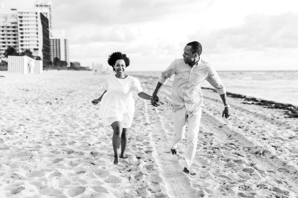 Daphne of De La Fleur Designs and fiance running down beach during Miami beach engagement session