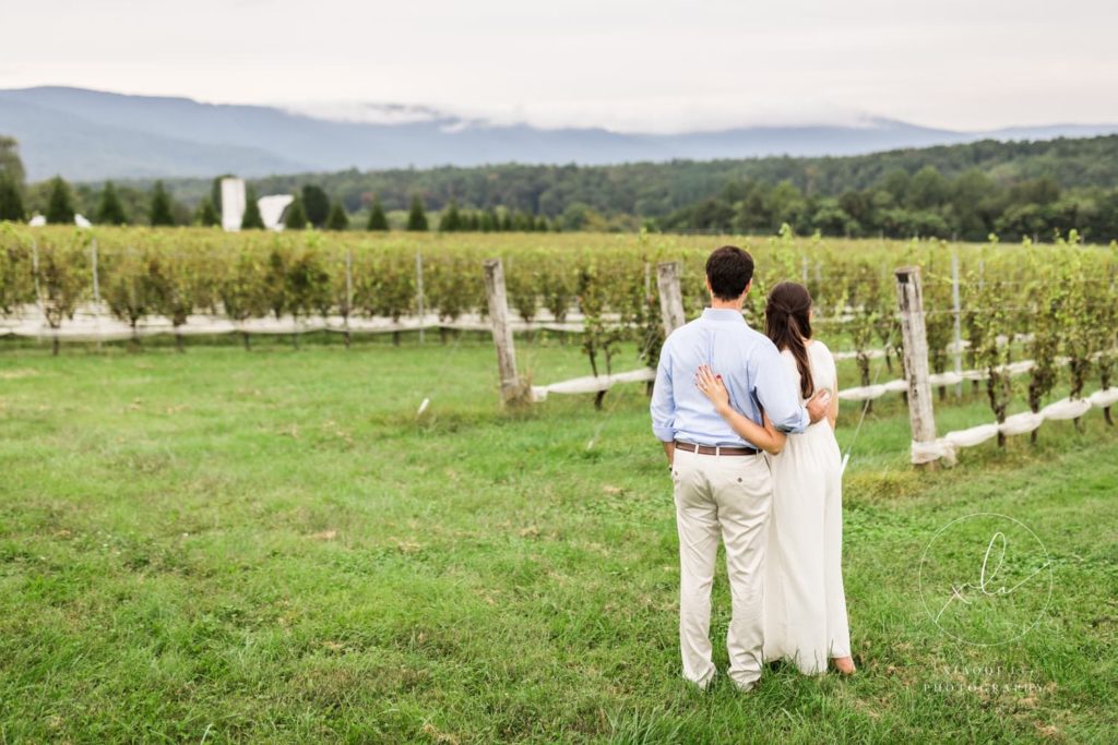 man and woman looking over vineyard