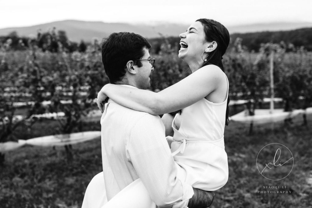 man picking up woman during spring vineyard engagement session
