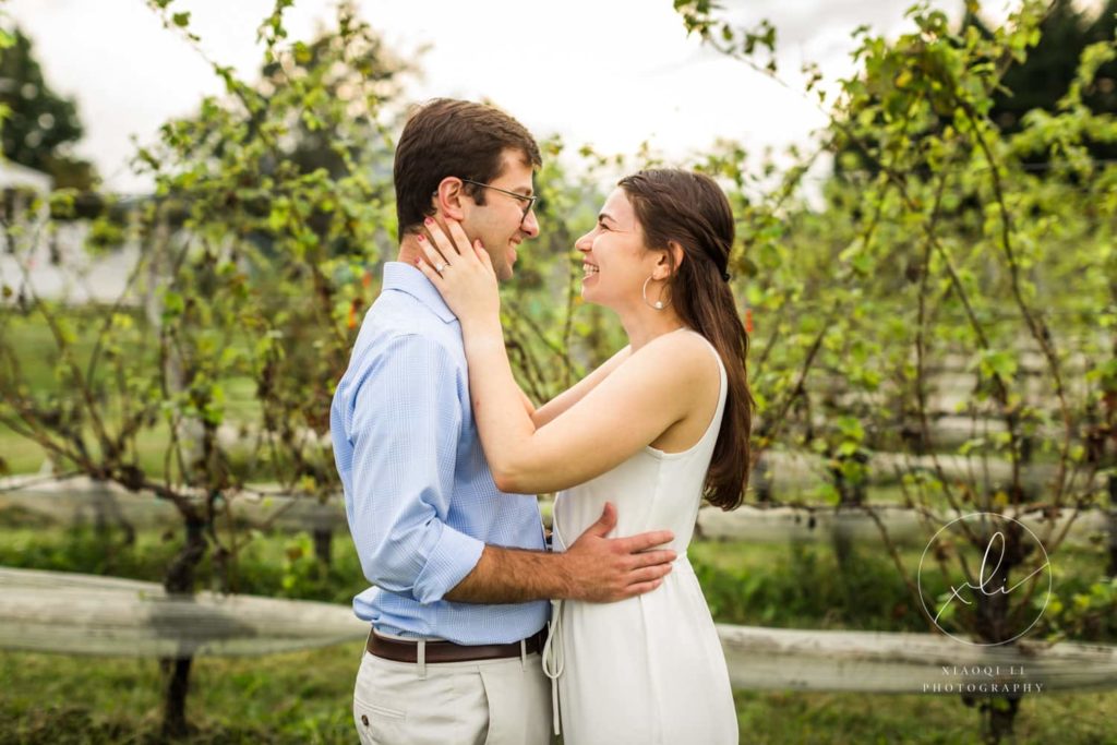 man and woman embracing during spring vineyard engagement session