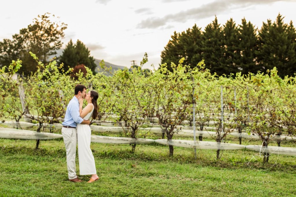 man and woman kissing in vineyard