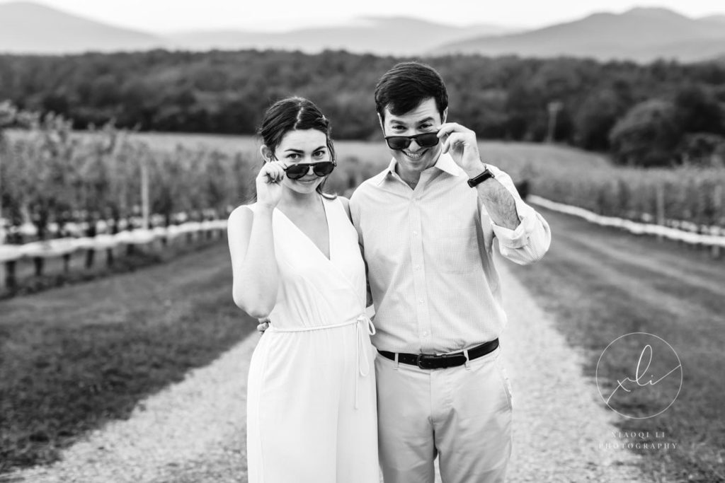 man and woman peeking over sunglasses