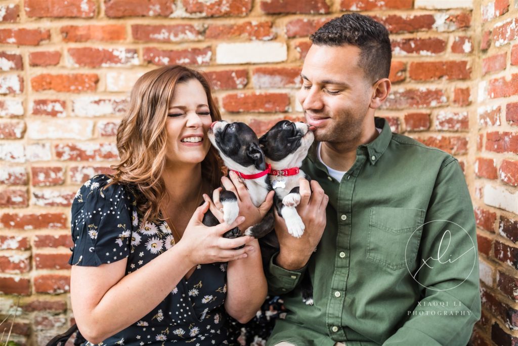 Engaged couple holding two puppies