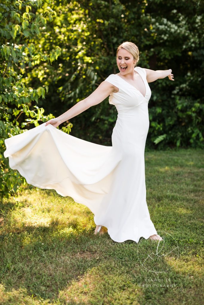 Bride wearing wedding gown outside twirling her dress