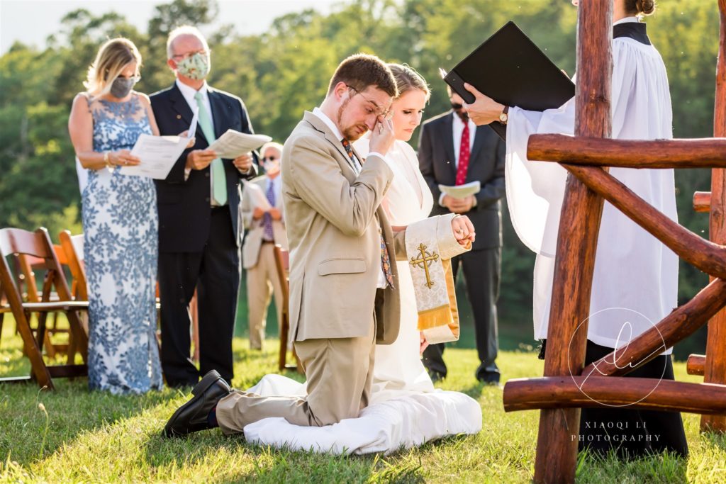Couple kneeling during wedding ceremony to pray together 