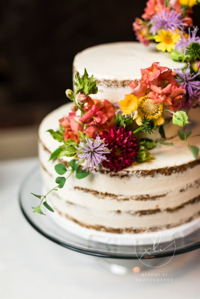 Rustic chic wedding cake with colorful flowers at episcopal wedding