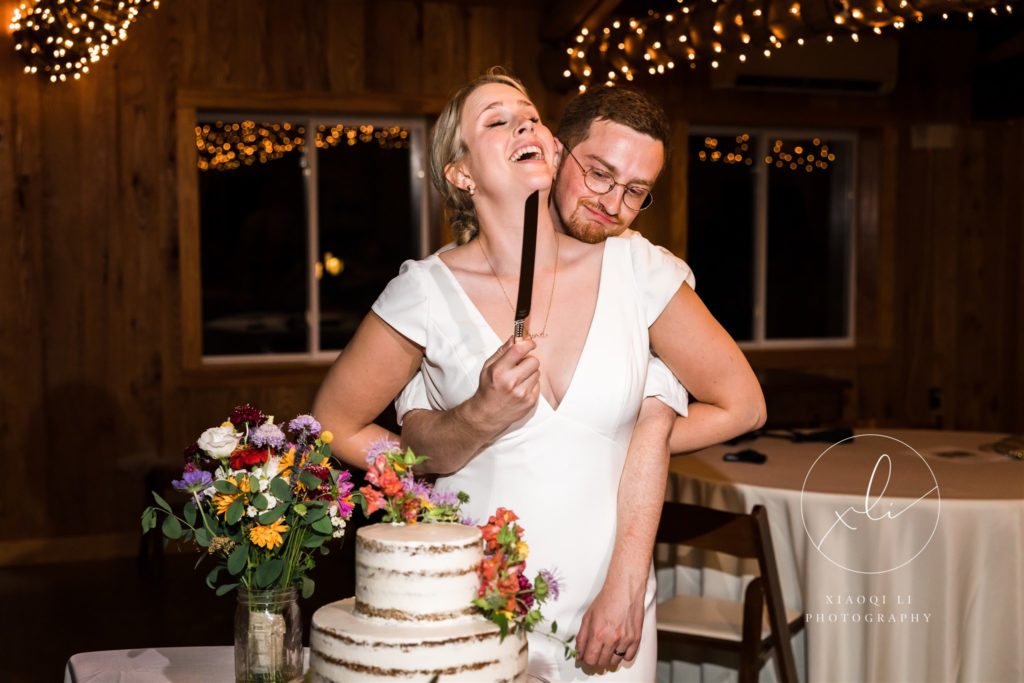 Newly married couple getting ready to cut wedding cake