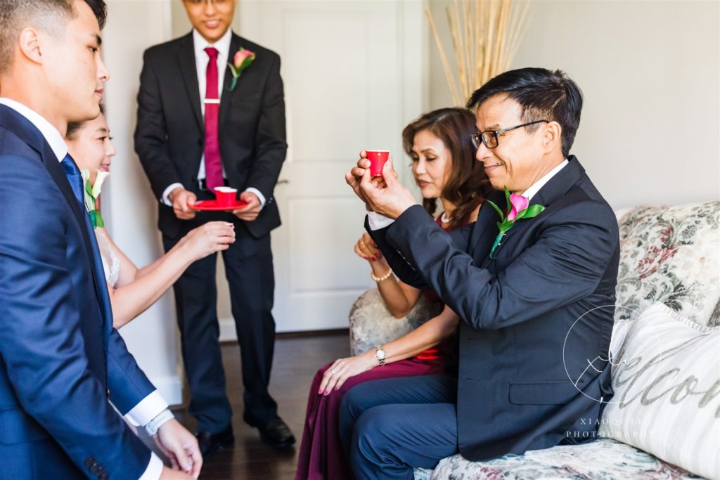 Parents presenting couple with gifts on wedding day during ceremony