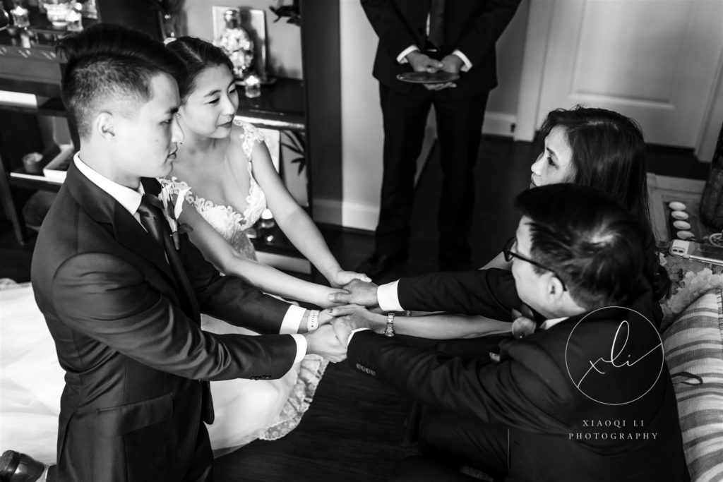Couple holding parents' hands during ceremony while receiving gifts and advice