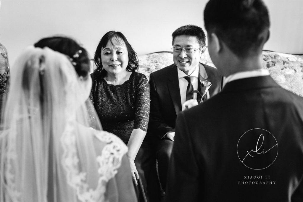 Couple on wedding day receiving advice and words of encouragement from parents during tea ceremony