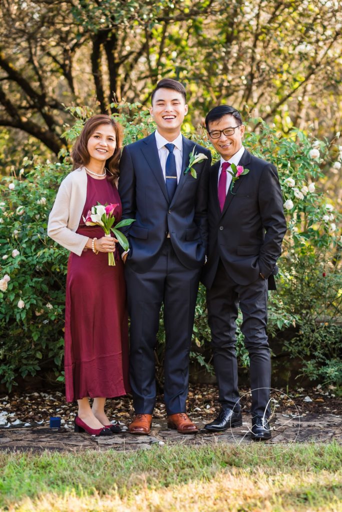 Groom standing and smiling next to his parents after Richmond wedding