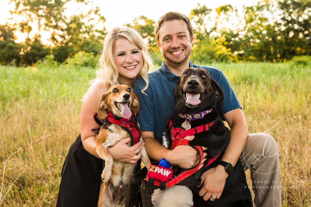 man and woman holding puppies and smiling during outdoor photo session