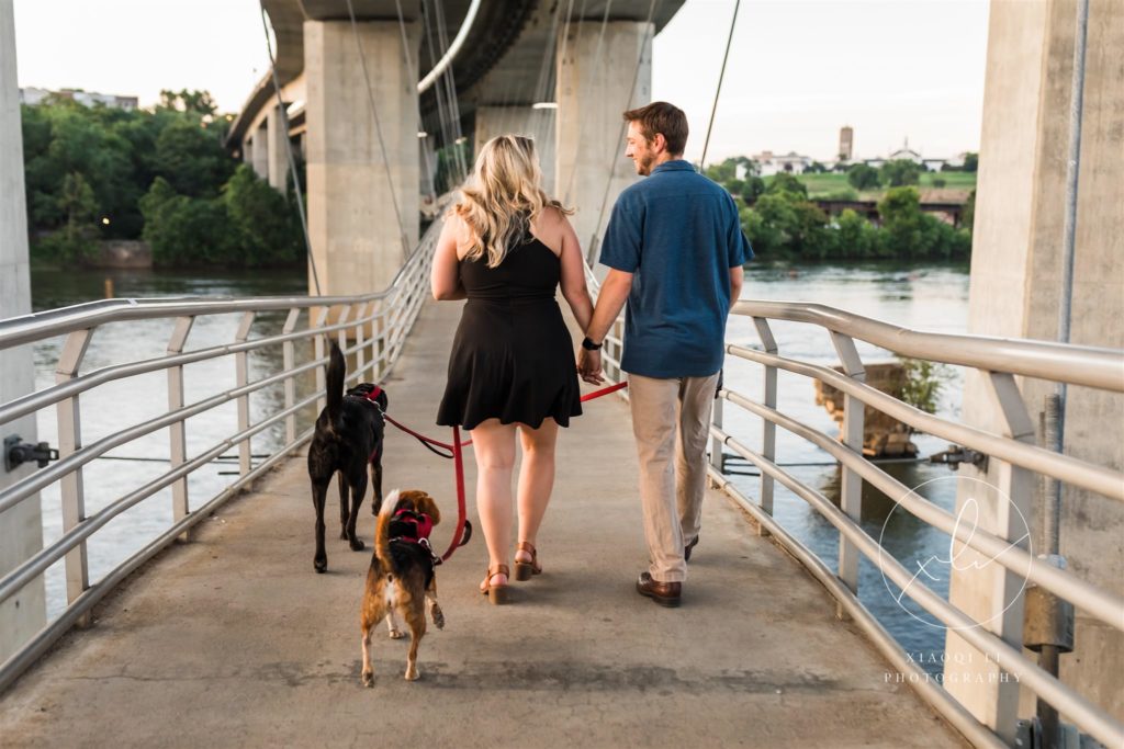 engaged couple walking off with pups after Belle Isle engagement session
