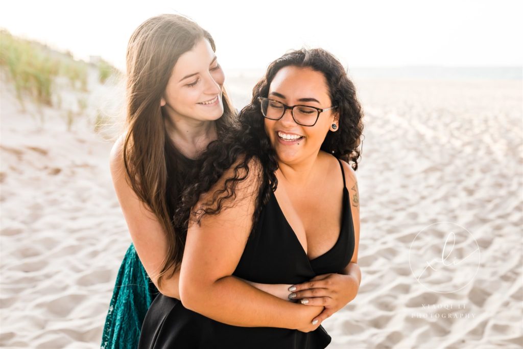 Emily and Sophie on beach hugging during chicks beach engagement session