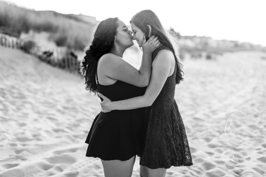 Newly engaged couple kissing on chick's beach in Virginia