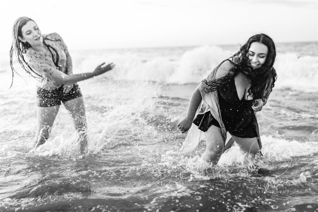 Emily and Sophie splashing in the water during engagement session