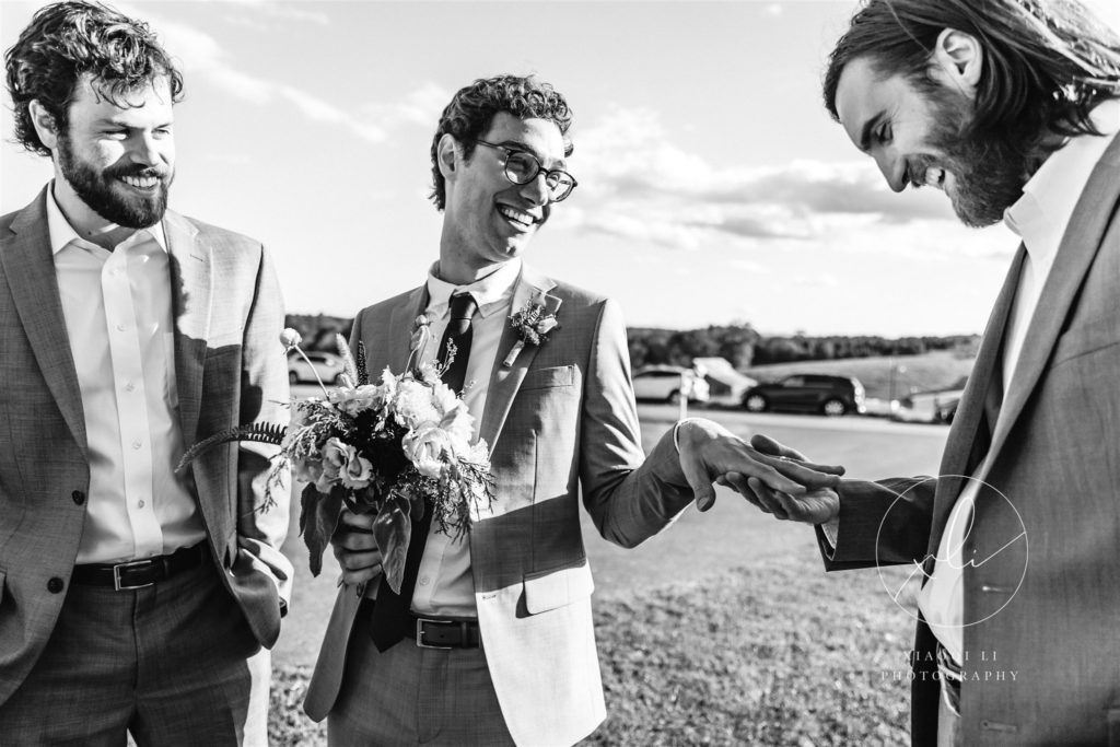 men laughing while congratulating friend on recent marriage and looking at his ring