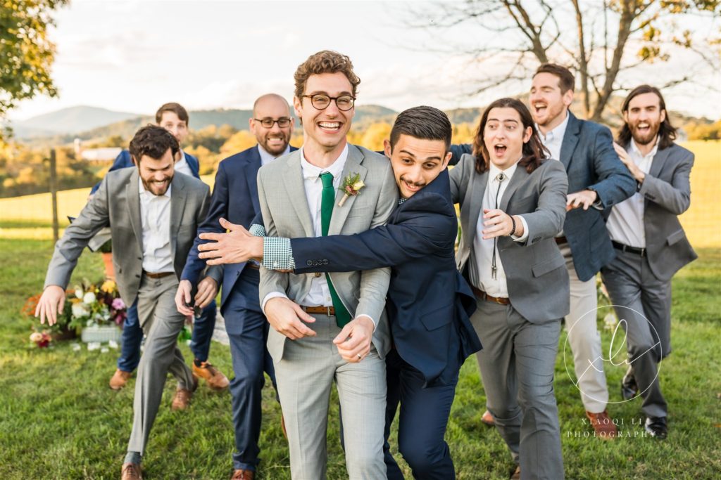 groomsmen running after groom and hugging him on Charlottesville wedding day