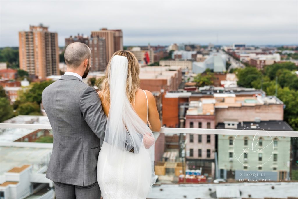 couple staring off into the Richmond skyline in wedding gown and suit