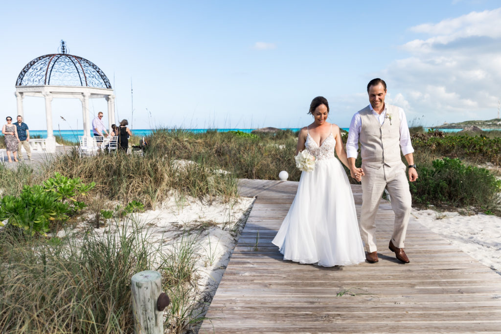 Couple walking down the pier as husband and wife after exuma beach wedding
