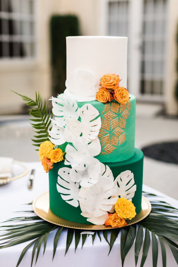 brightly colored tropical cuban inspired wedding cake with green and orange flowers