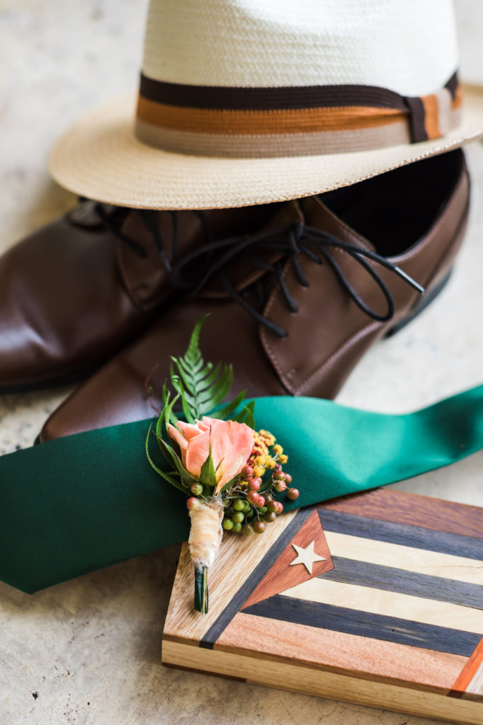 groom's details with white fedora, brown dress shoes, and emerald green tie