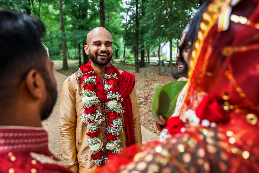 Groom smiling and looking at bride in gold robe before traditional wedding ceremony