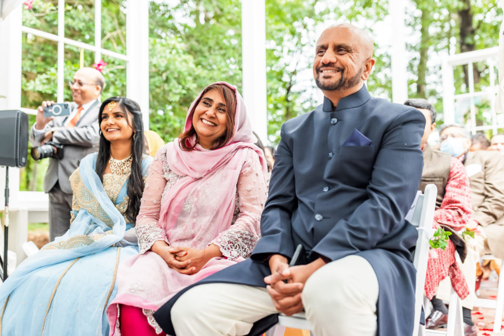 family sitting and smiling during wedding ceremony