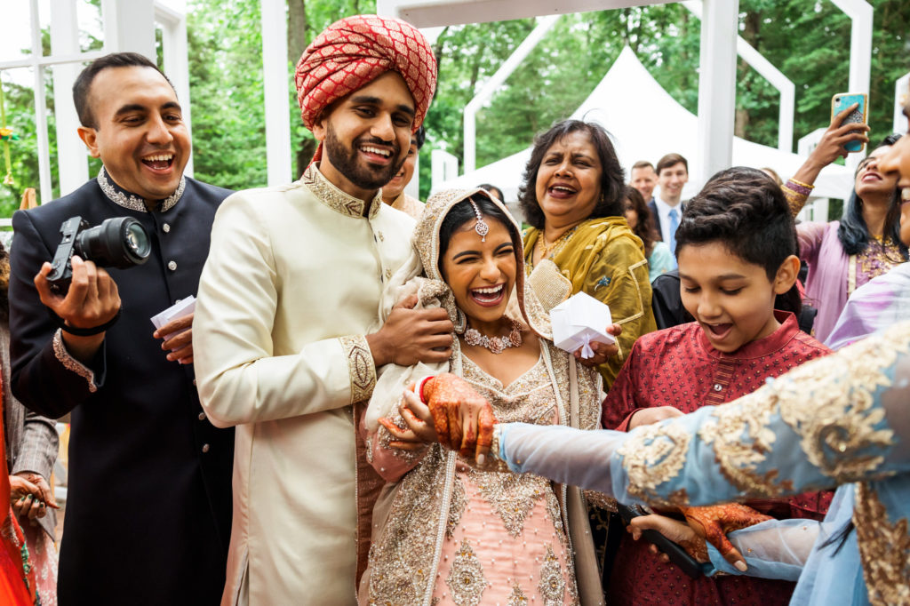groom laughing with family having fun celebrating hindu muslim interfaith wedding