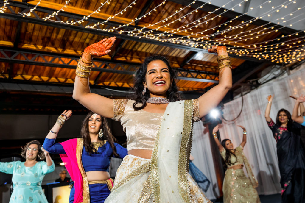 bride smiling and dancing having a good time at hindu muslim interfaith wedding reception
