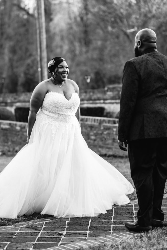bride spins around and shows groom her wedding gown for first look on wedding day