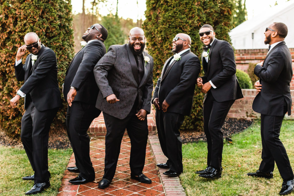 Groom dancing and having fun with groomsmen wearing all black suit and tie for Mankin Mansion wedding
