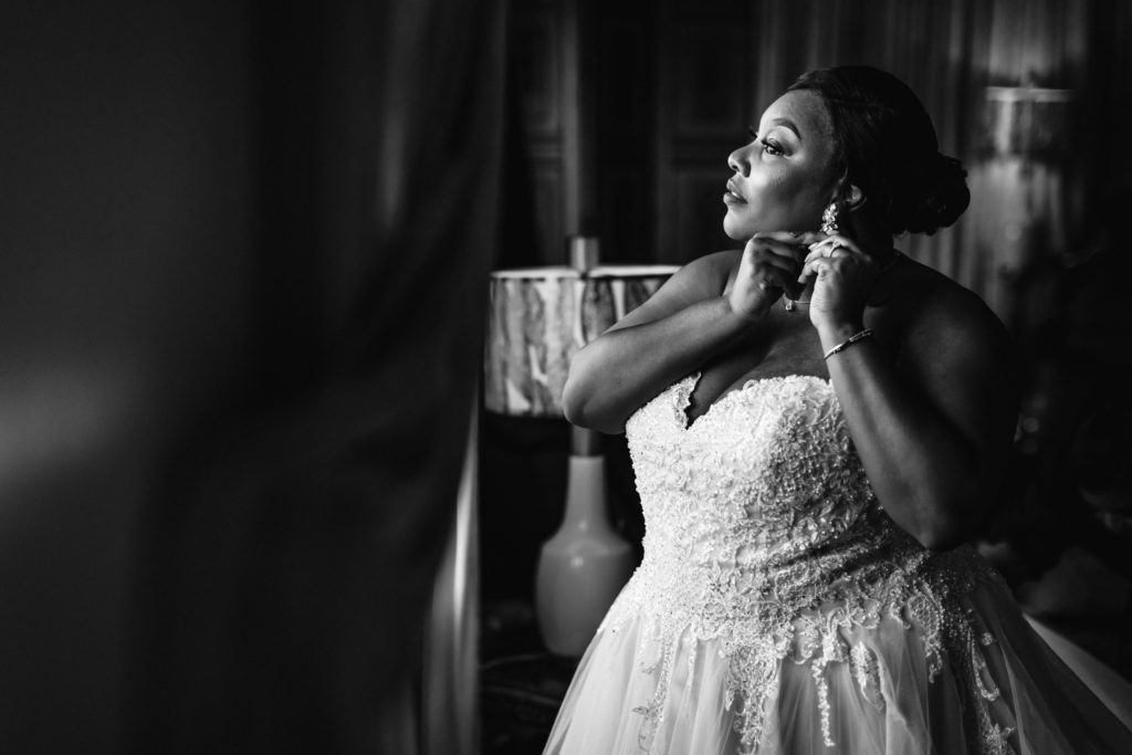 bride putting earrings on before mankin mansion wedding