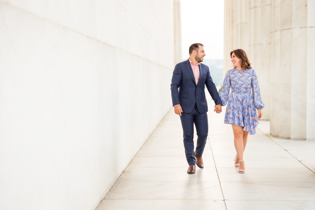 man and woman walking hand in hand during kennedy center engagement session