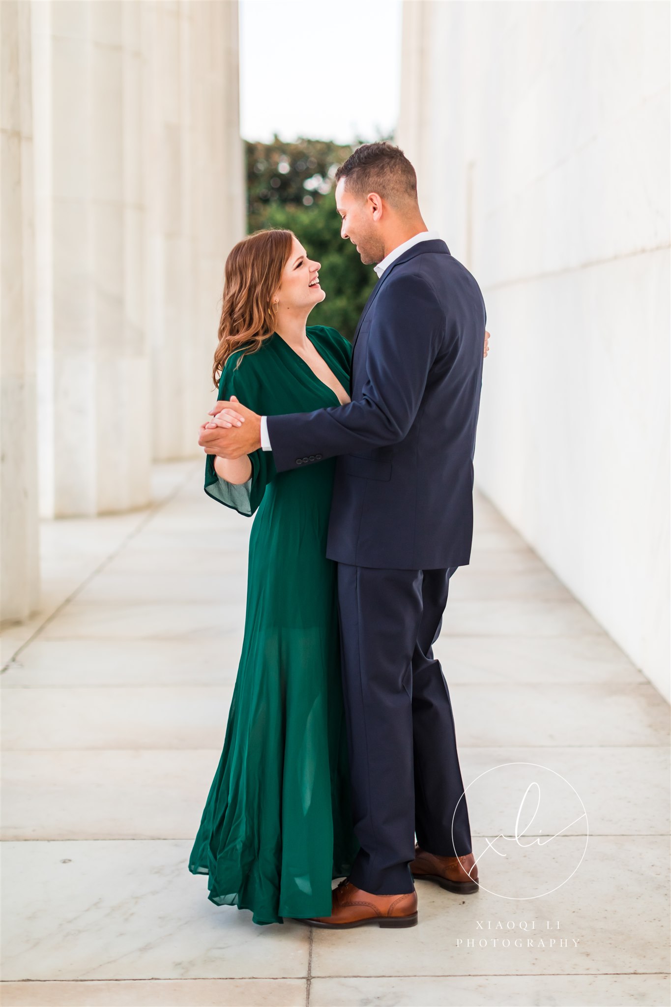 man and woman dancing at Lincoln Memorial in formal attire, woman wearing emerald dress and man wearing suit