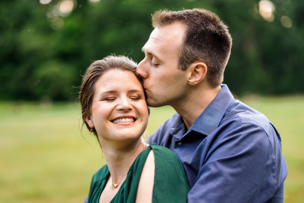 man kissing woman's cheek during engagement session outdoors in Charlottesville