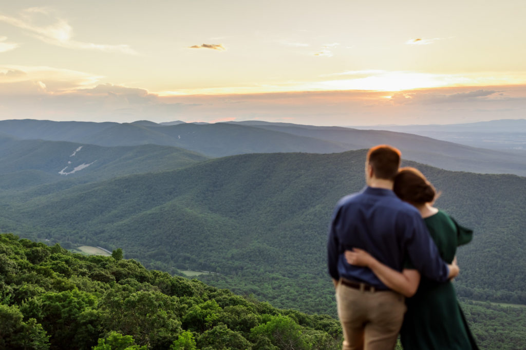 engaged couple looking over at the mountains during engagement session at Ravens Roost