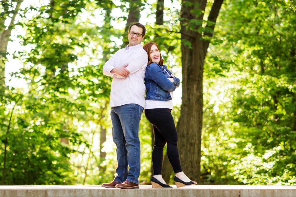 couple standing back to back in theodore park during engagement session