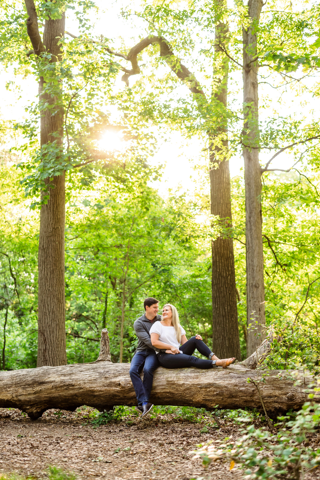 couple sitting on log during sunrise DC engagement session at Fort Slocum Park