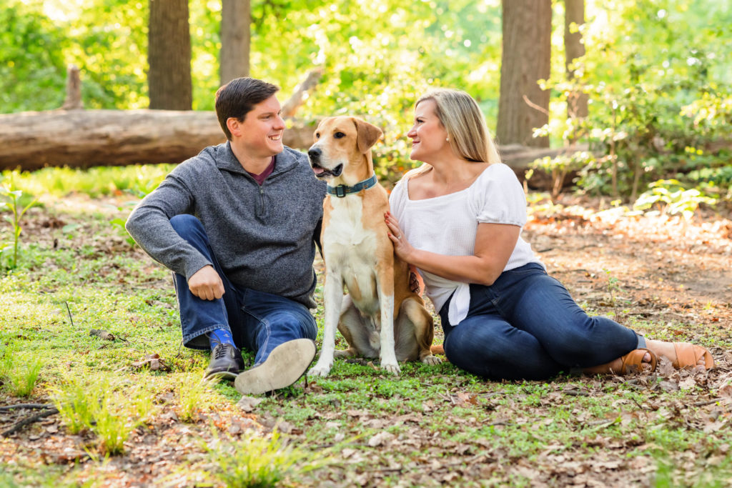engaged couple sitting with dog during sunrise dc engagement session at fort slocum