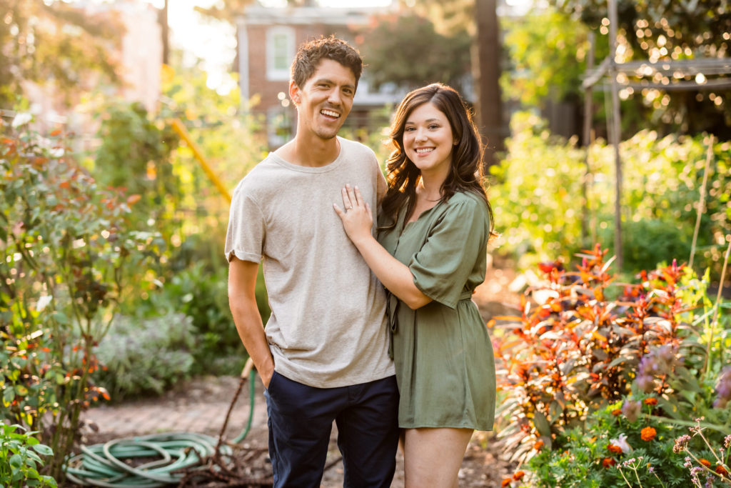 engaged couple standing together in greenery filled area
