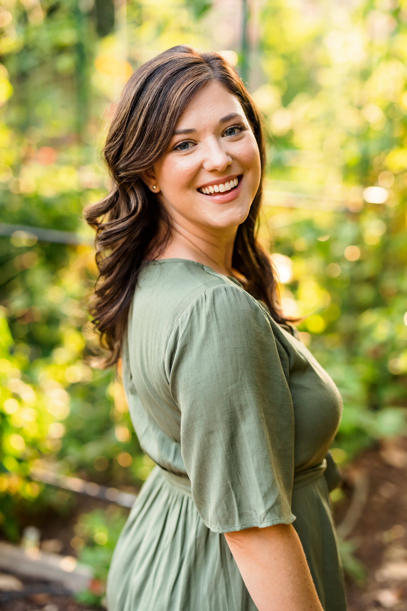 Aspen smiling wearing green dress during scuffletown park engagement session