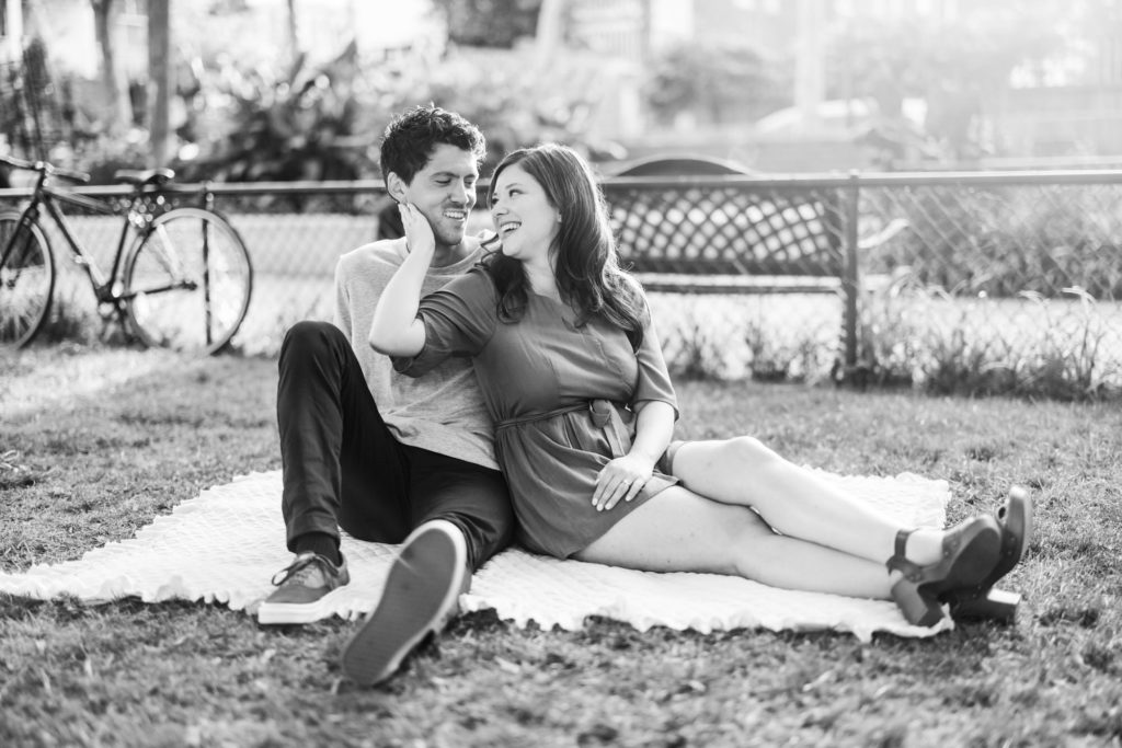 engaged couple sitting on blanket smiling during scuffletown park engagement session