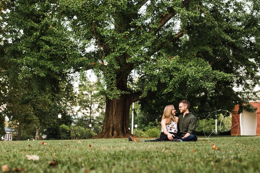 couple sitting in the lawn of university of virginia together during engagement session