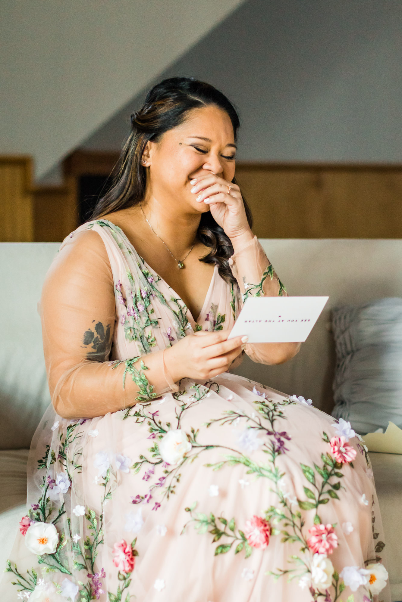 bride reading letter from groom and laughing on wedding day in Charlottesville