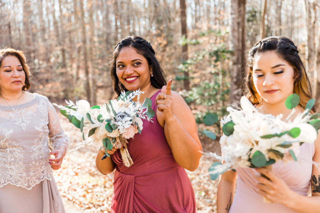 bridesmaids cheering on bride in pink gowns as she walked down the aisle